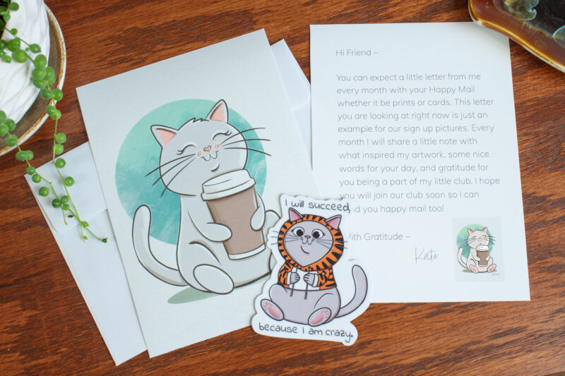 Cat Print Club sample art mail photographed with club materials